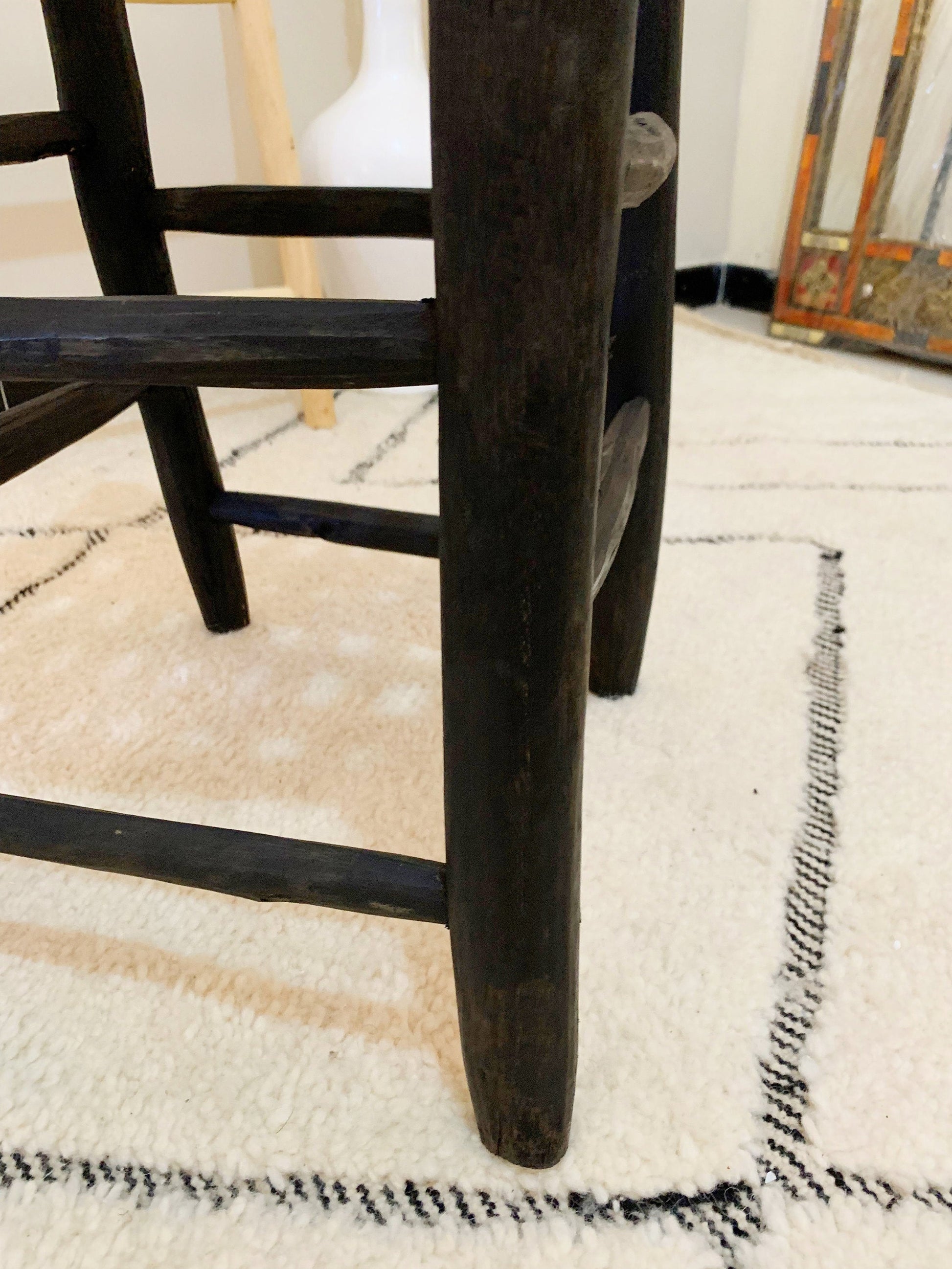 a wooden chair sitting on top of a white rug