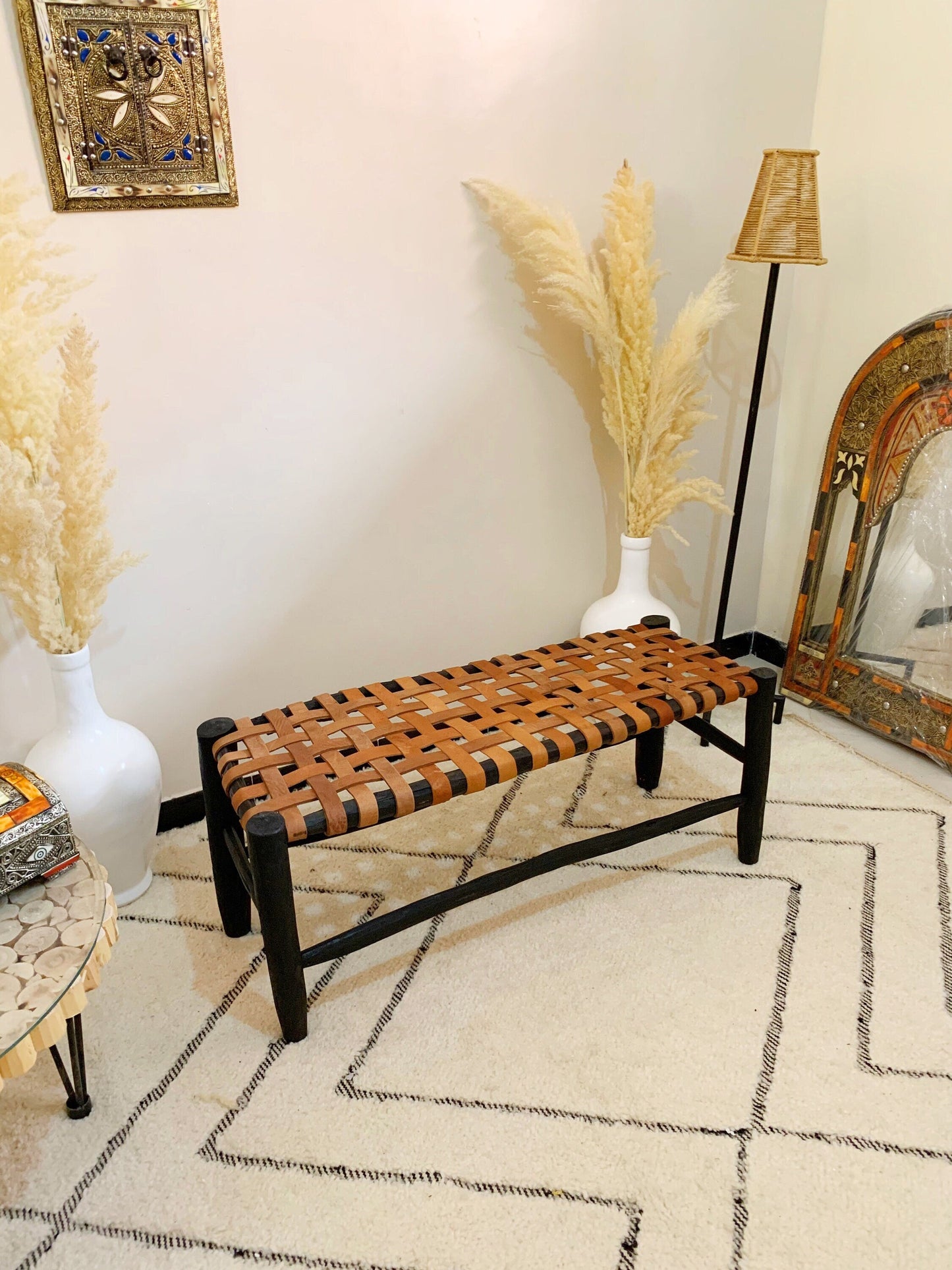 a wooden bench sitting in a living room next to a mirror