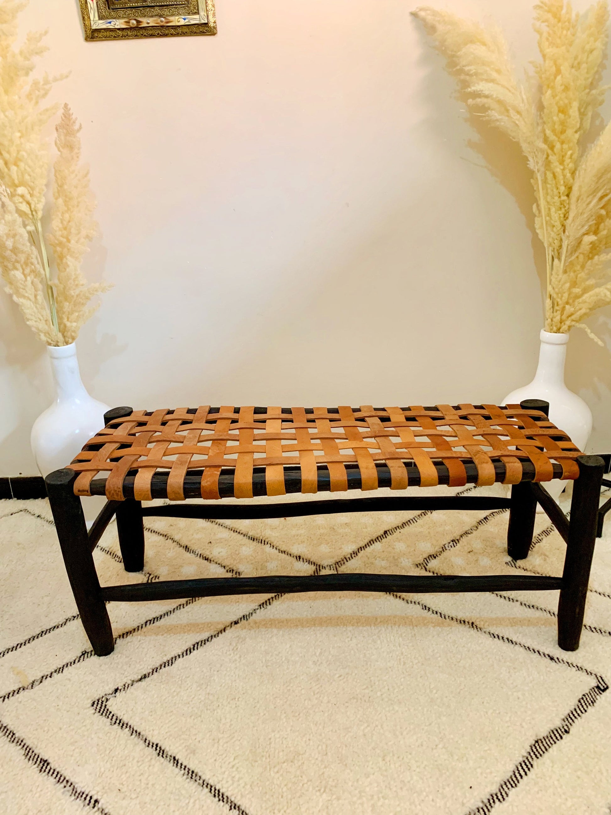 a wooden bench sitting on top of a rug